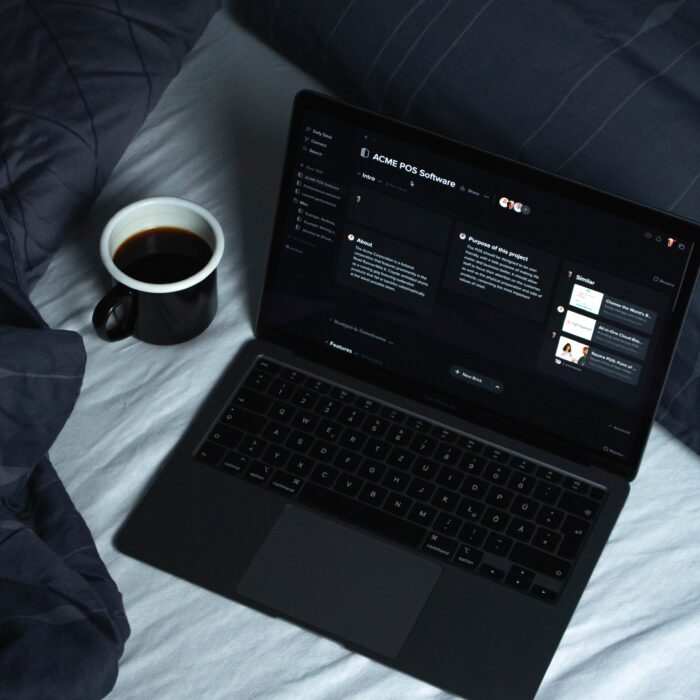 black laptop computer on white textile